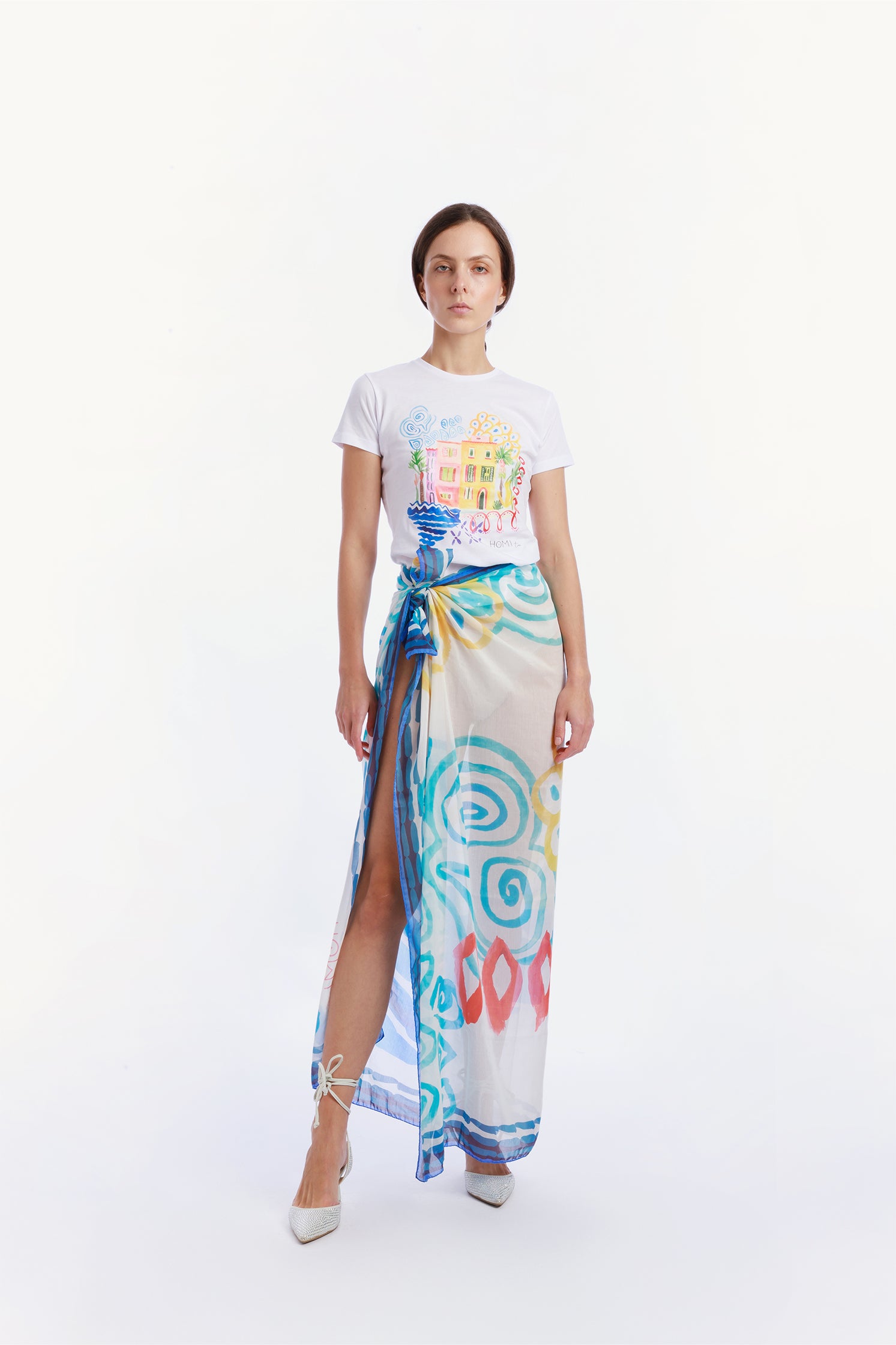 Large 140x140 cm lightweight scarf in cotton and silk, featuring an elegant print of stylized waves evoking the movement and calm of the sea worn by a model as a skirt.