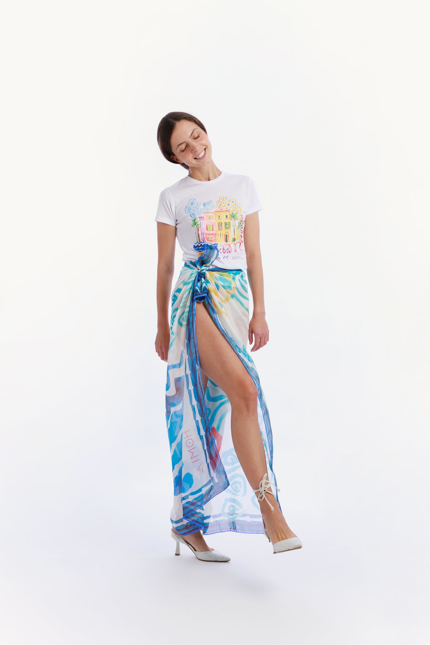 Large 140x140 cm lightweight scarf in cotton and silk, featuring an elegant print of stylized waves evoking the movement and calm of the sea worn by a model as a skirt.