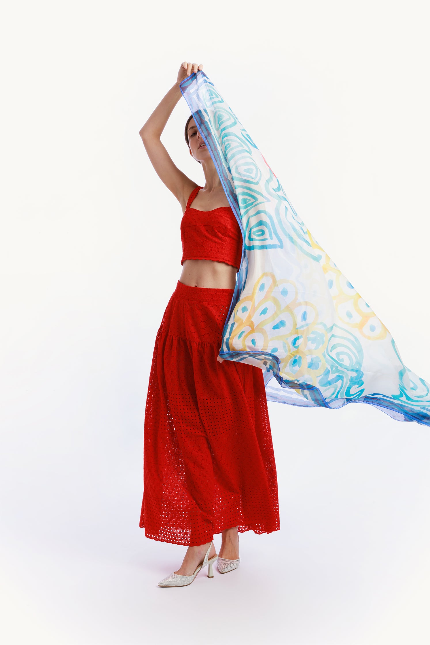 Large 140x140 cm lightweight scarf in cotton and silk, featuring an elegant print of stylized waves evoking the movement and calm of the sea held by a model.