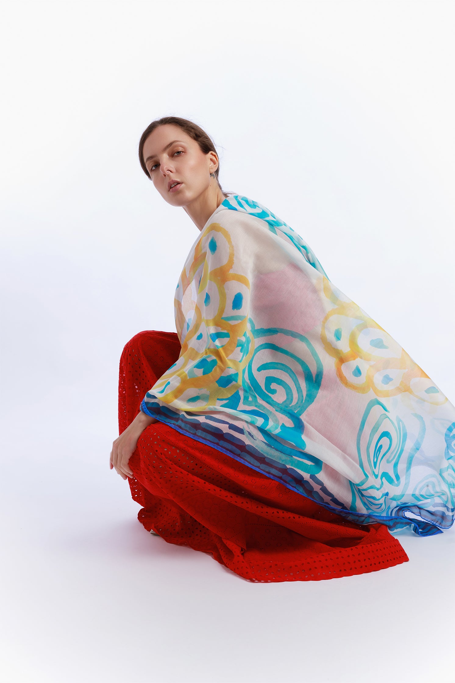 Large 140x140 cm lightweight scarf in cotton and silk, featuring an elegant print of stylized waves evoking the movement and calm of the sea worn by a model.