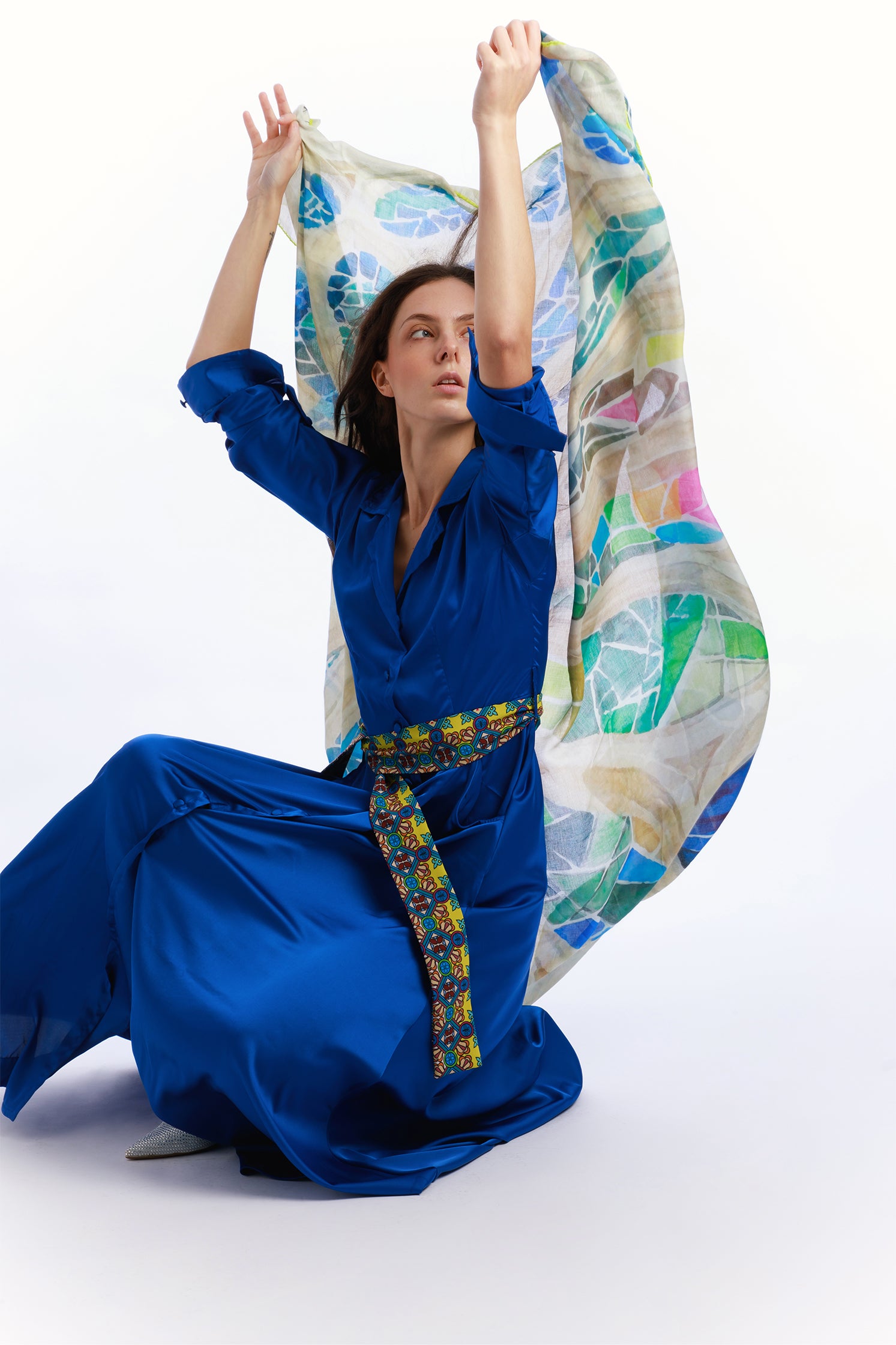 Large 140x140 cm scarf in modal and cashmere, featuring a refined print inspired by colorful stained glass windows, soft, enveloping, and elegant held by a model.