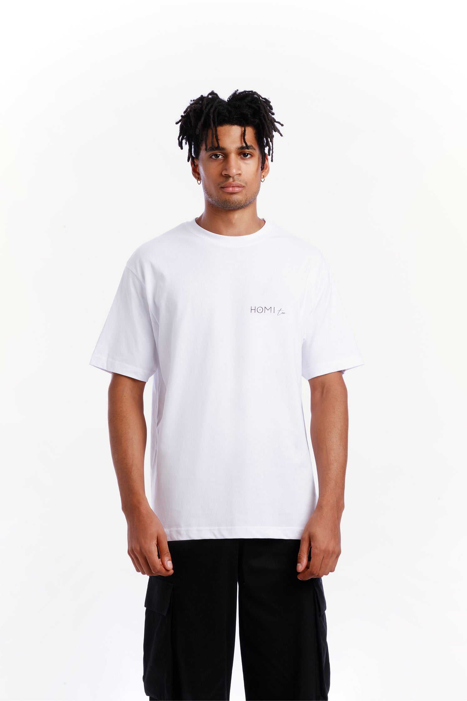 Front view of the oversized unisex white T-shirt made of high-quality cotton, worn by a model, featuring a modern cut, "Homi Too" logo on the left chest.