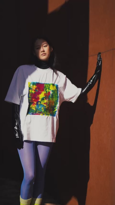 White unisex oversized T-shirt worn by a model, with central multicolor square hand-made using an exclusive silicone technique.