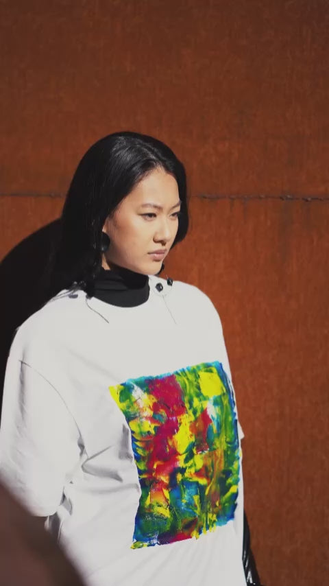 White unisex oversized T-shirt worn by a model, with central multicolor square hand-made using an exclusive silicone technique.